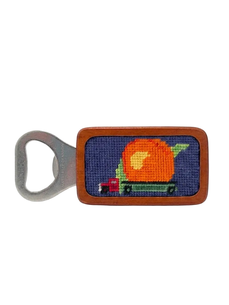 Bottle opener with needlepoint design of a peach on a white background