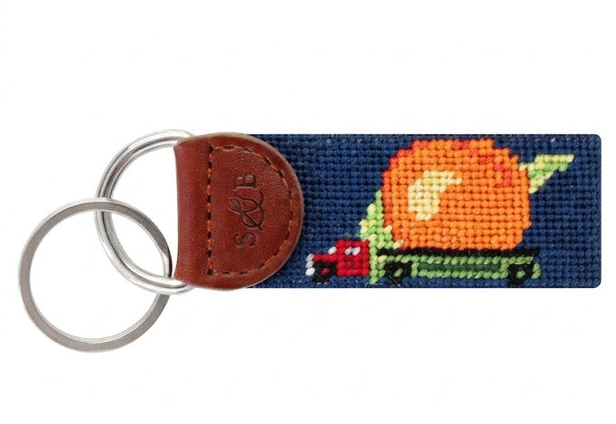 Keychain with needlepoint design of a pumpkin and leaves on a white background