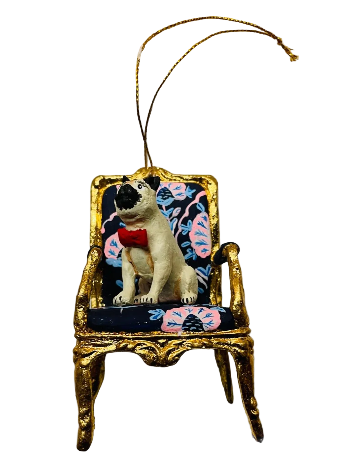 Decorative ornament of a pug in a chair on a scalloped edge plate.