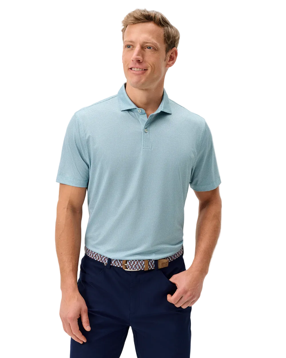 Man wearing a light blue patterned polo shirt and dark blue pants on a light gray background