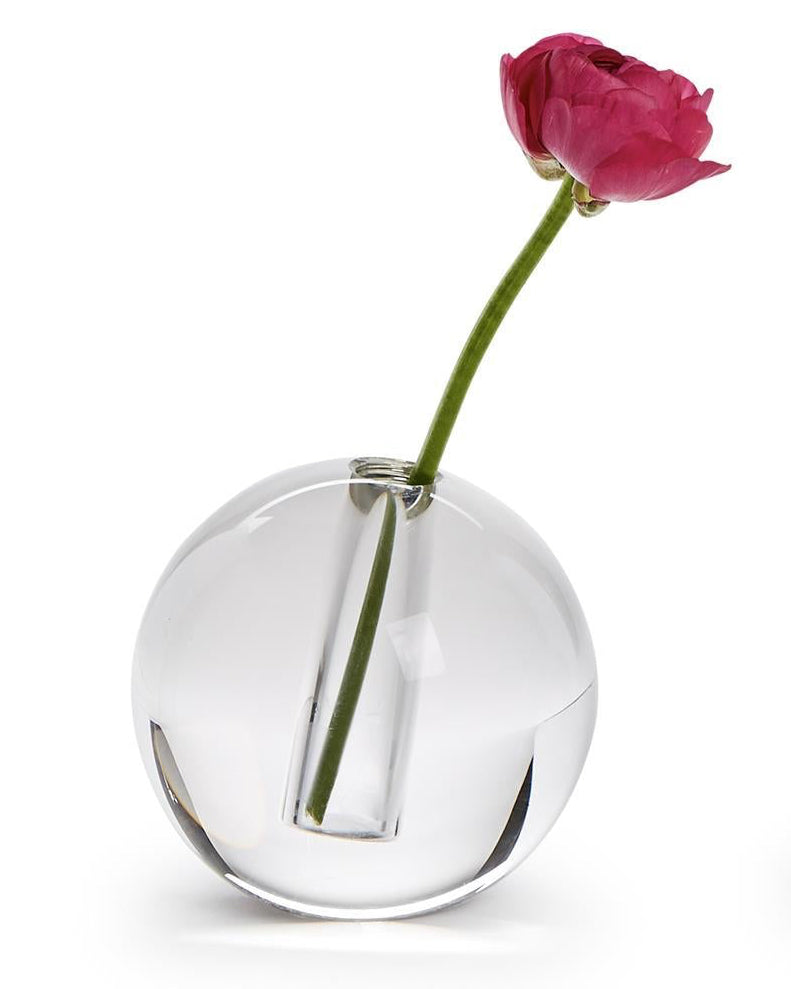 Clear spherical vase with a single pink flower on a white background