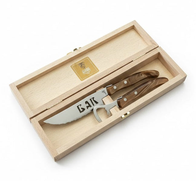 Set of knives with a bottle opener in a wooden box on a white background