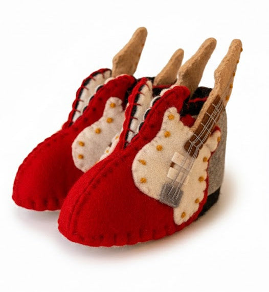 Red slippers with guitar design on a white background