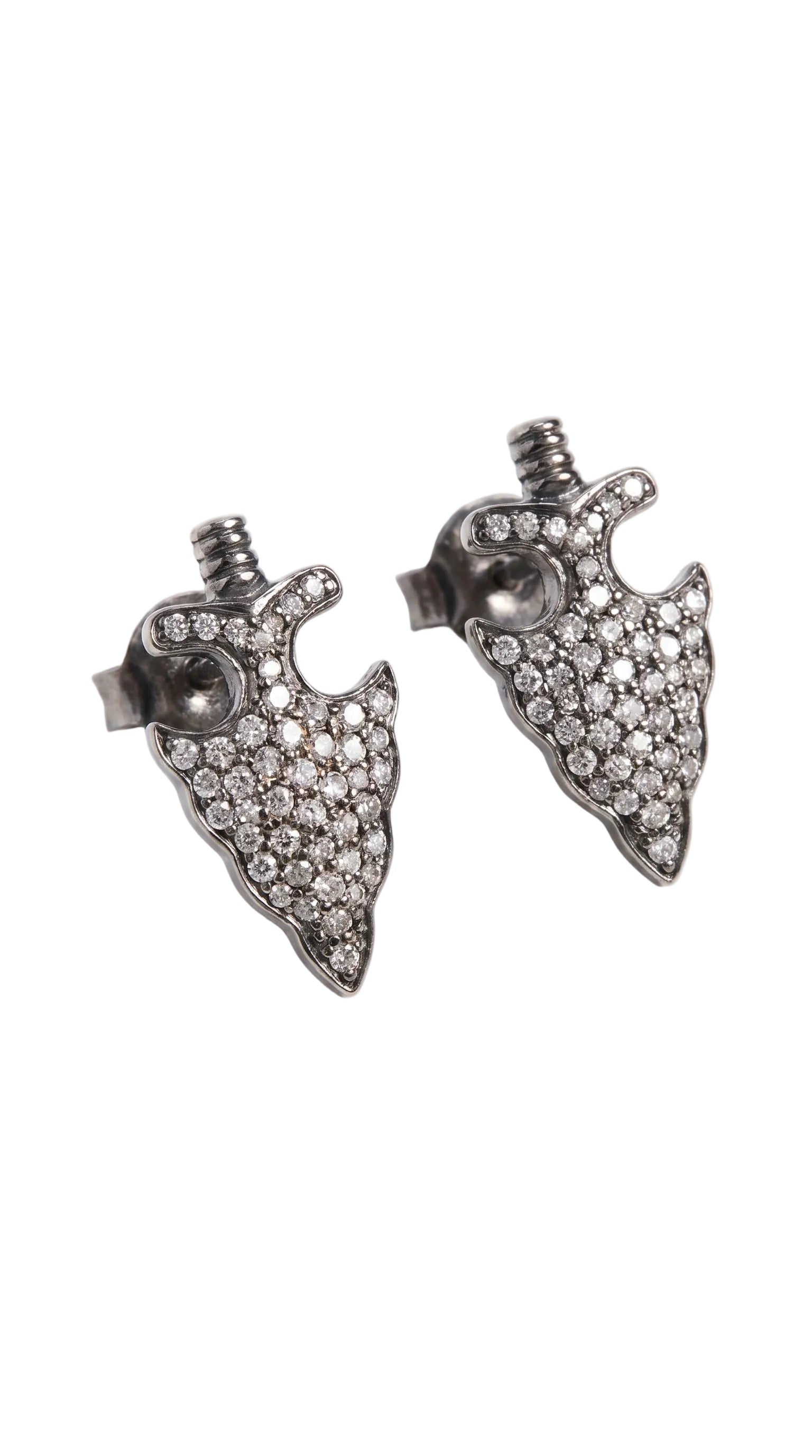 A pair of silver-toned arrowhead stud earrings paved with small clear crystals, shown on a light gray background.