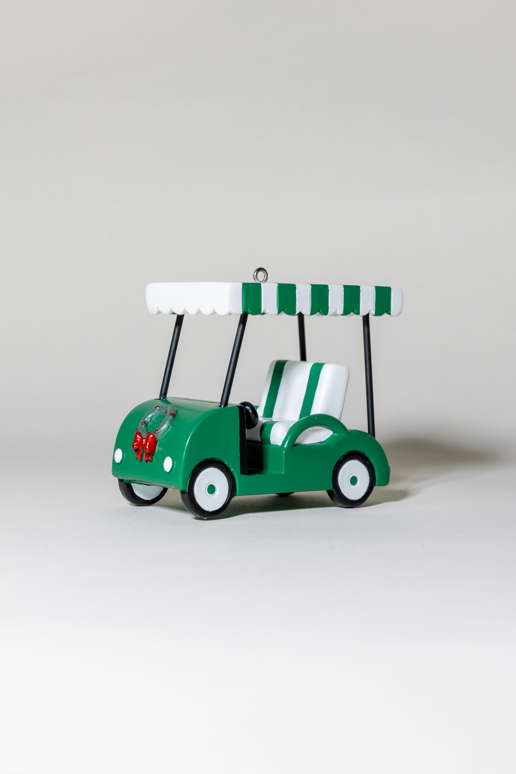 Green toy golf cart with a canopy on a light gray background