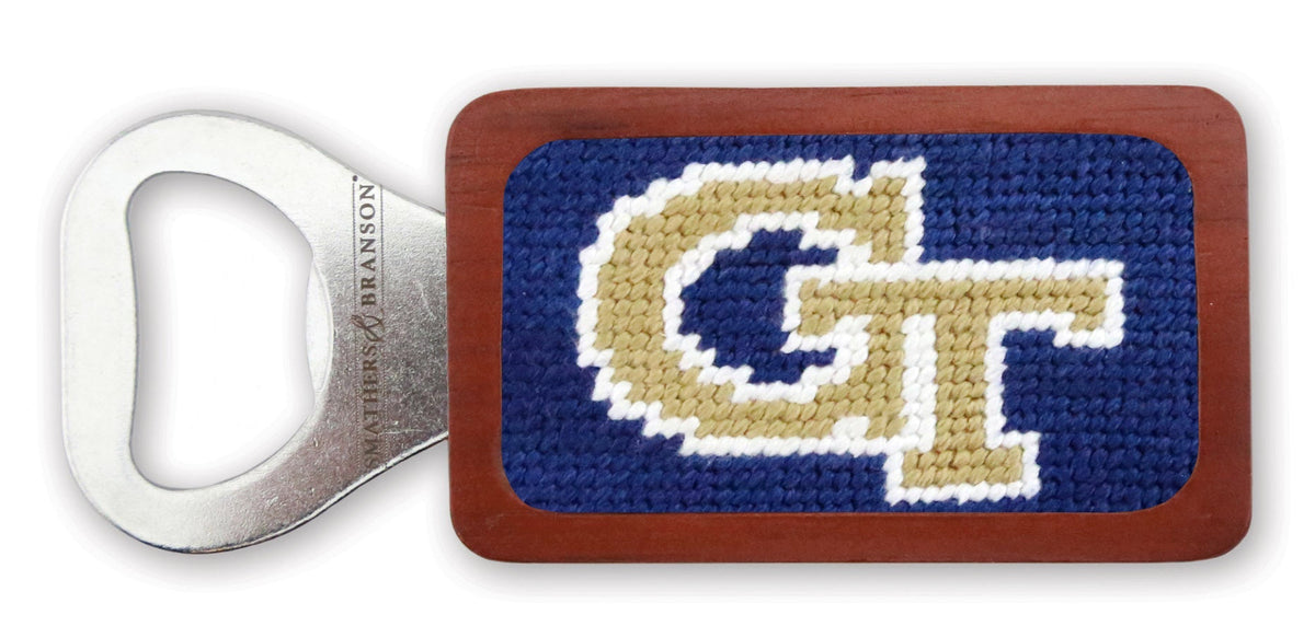 Bottle opener with needlepoint design featuring 'GT' logo on a white background