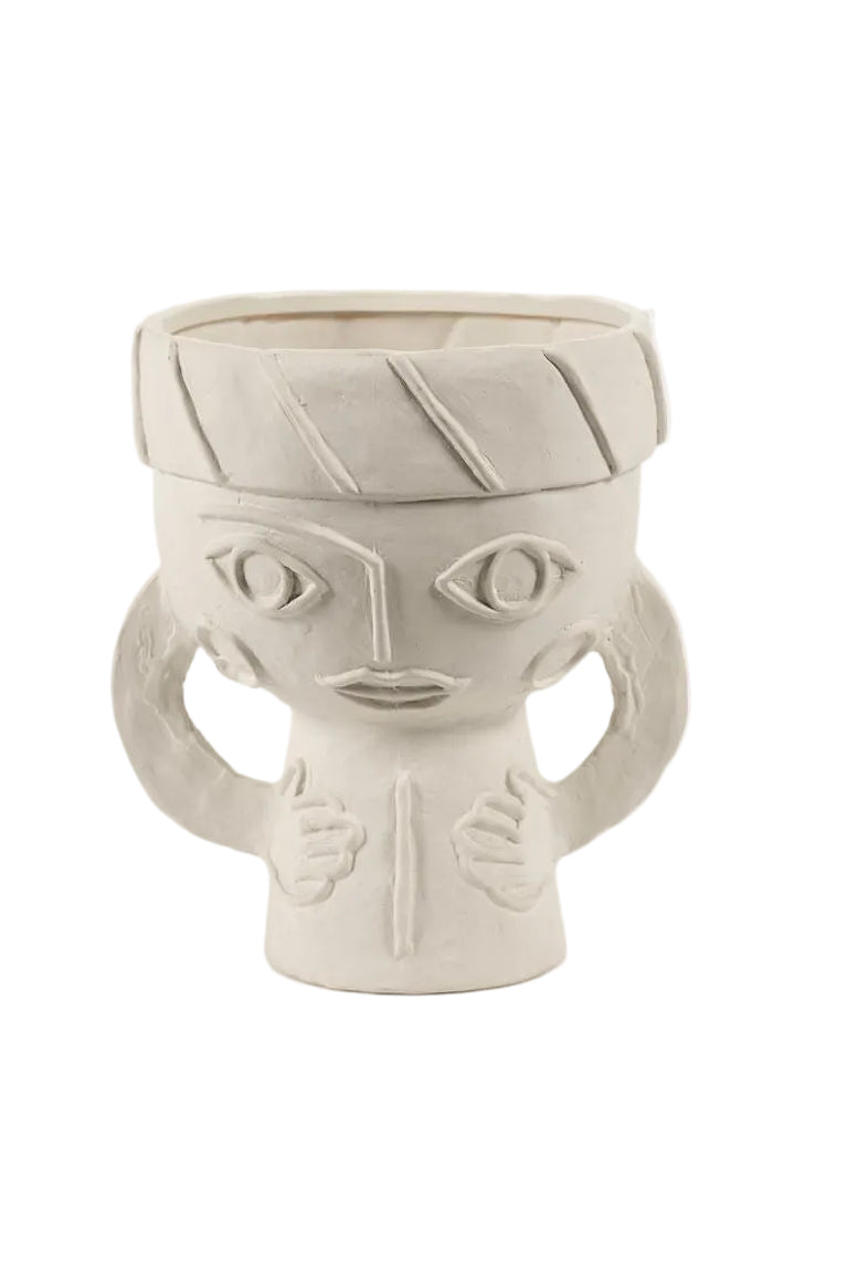Ceramic vase with face design on a white background