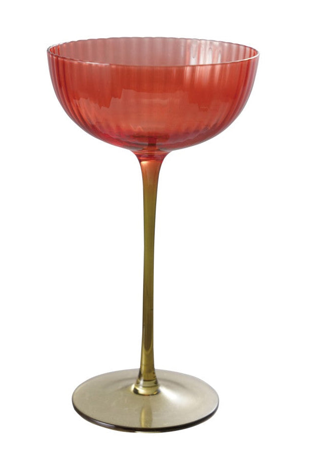 Red glass cocktail glass with gold base on a white background