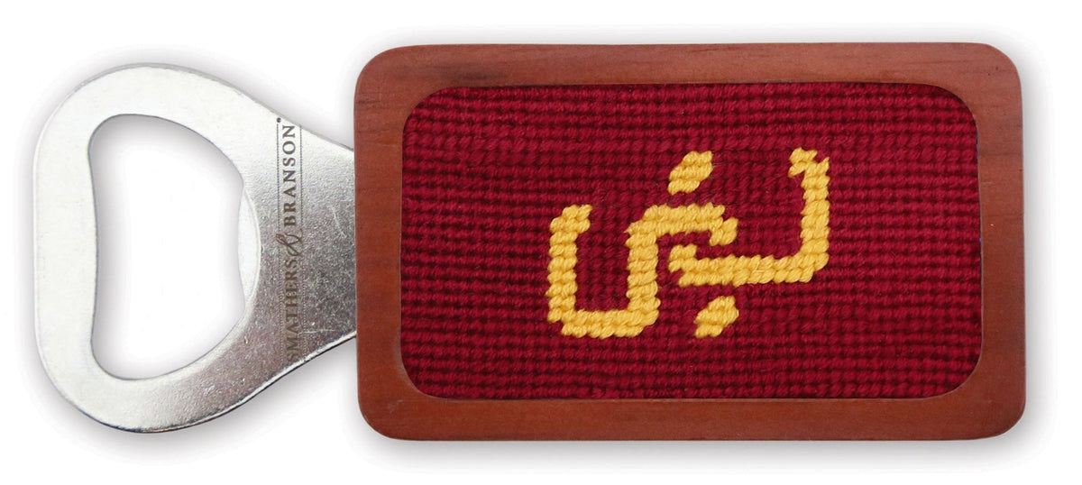 Bottle opener with red needlepoint design on a white background