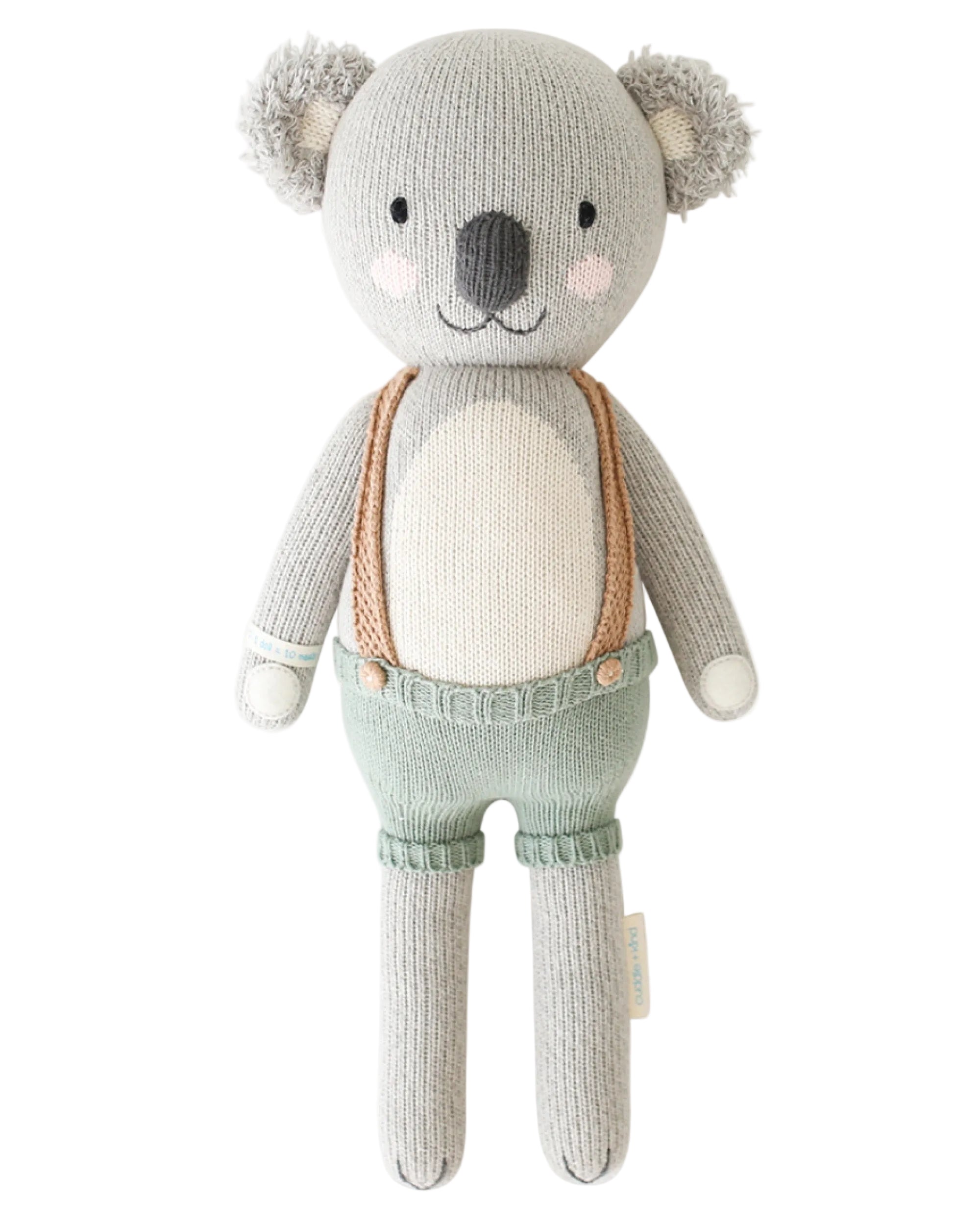 Knitted toy koala with suspenders on a white background