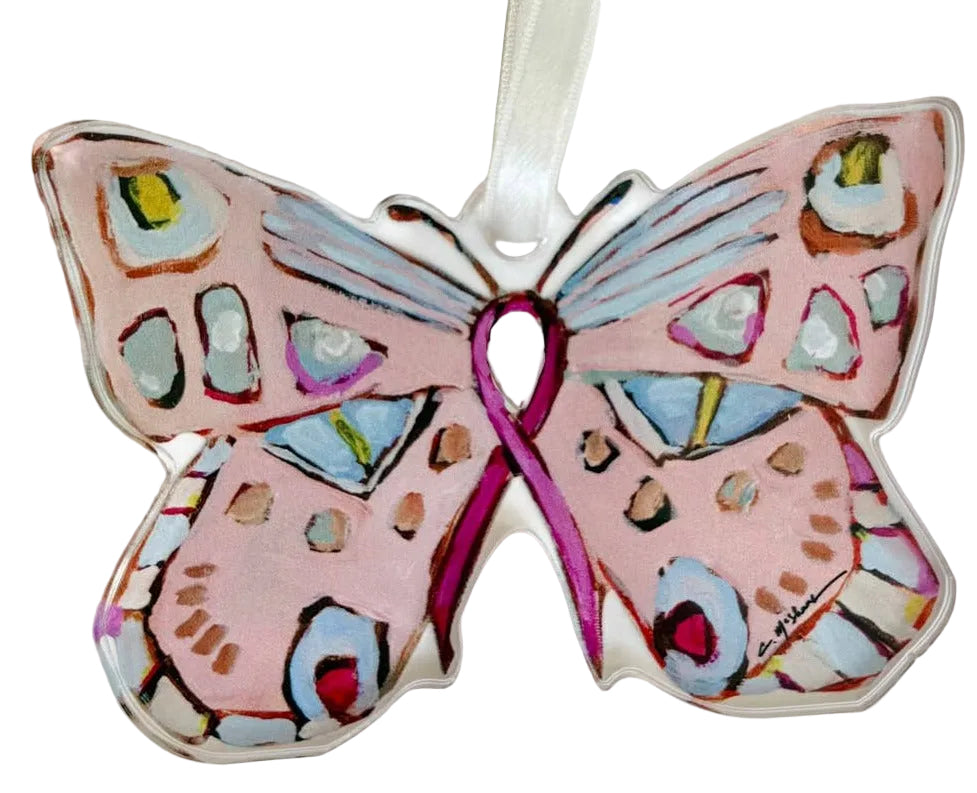 A butterfly-shaped ornament with a pink ribbon printed in the center, decorated with multicolored geometric patterns and hanging from a white ribbon on a plain white background.