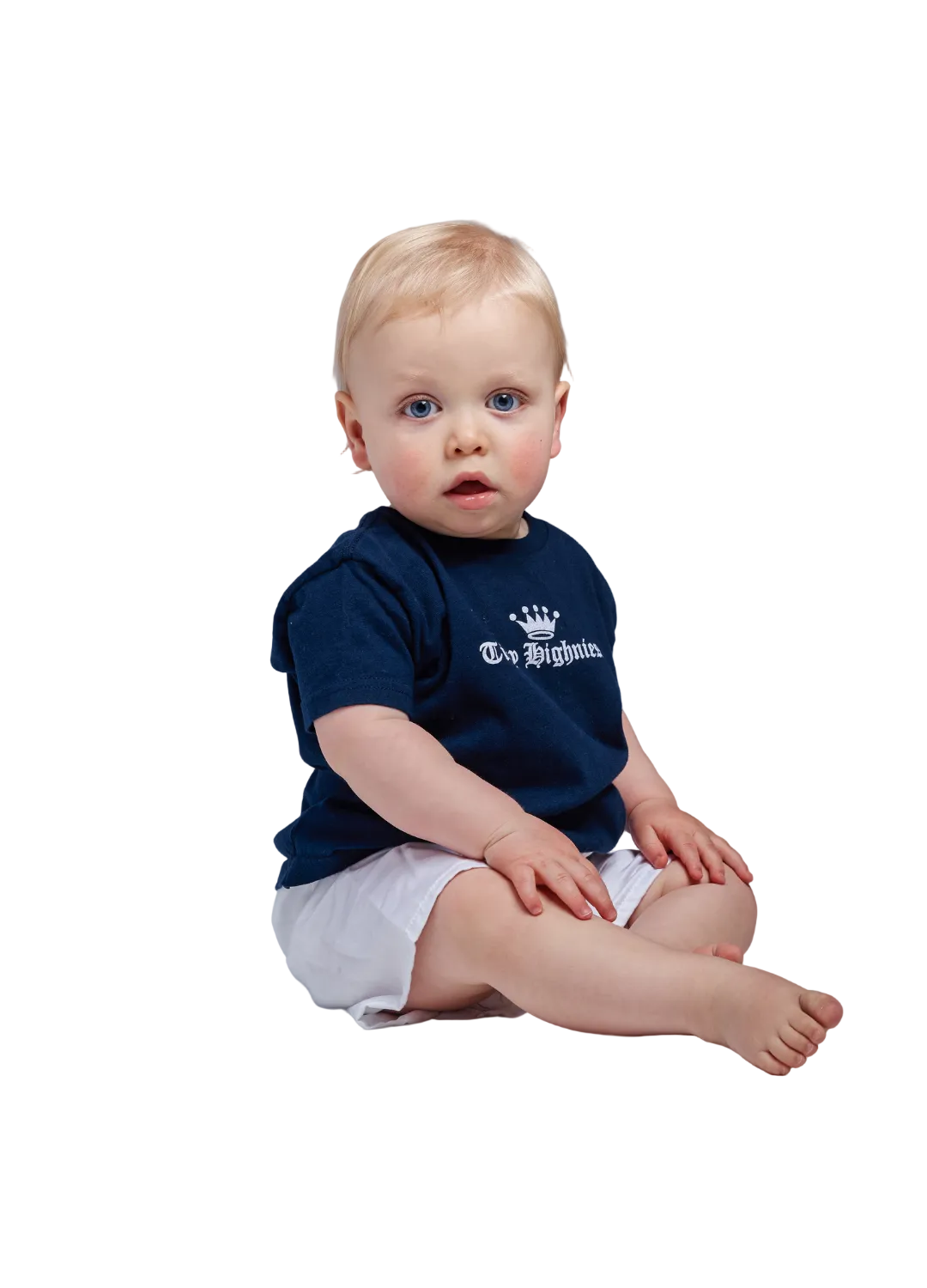 Baby sitting on a plain background wearing a navy blue shirt with white text and white shorts.