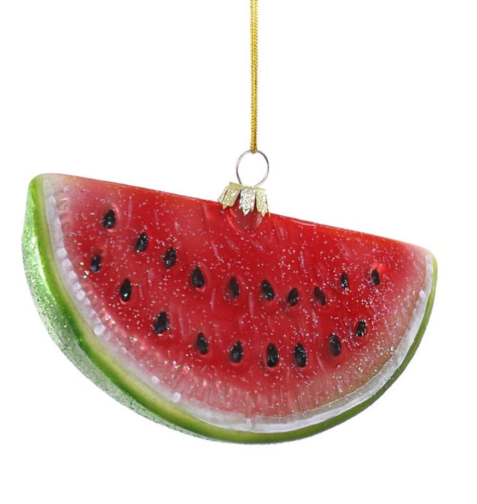 A watermelon slice Christmas ornament hanging from a gold string against a plain white background.