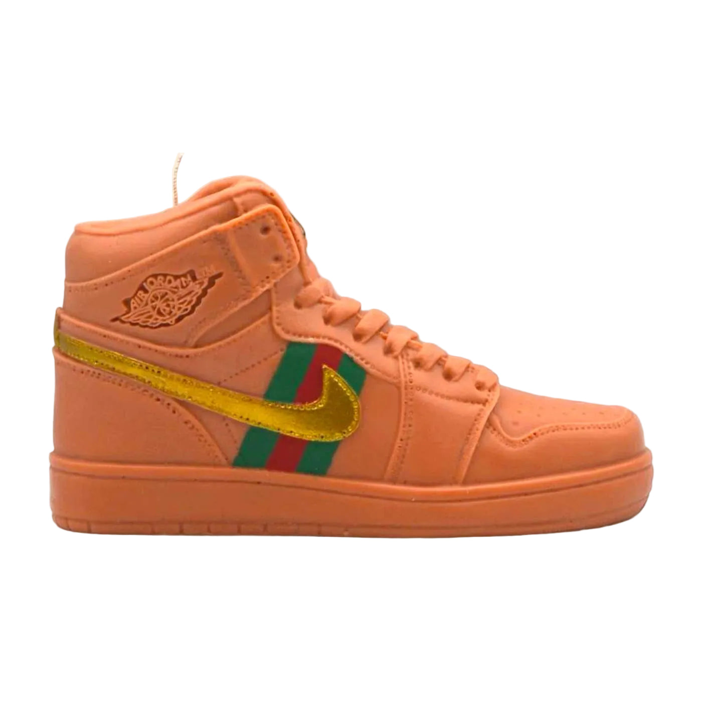 Orange sneaker candle  with a gold, green and red stripes on a beige background