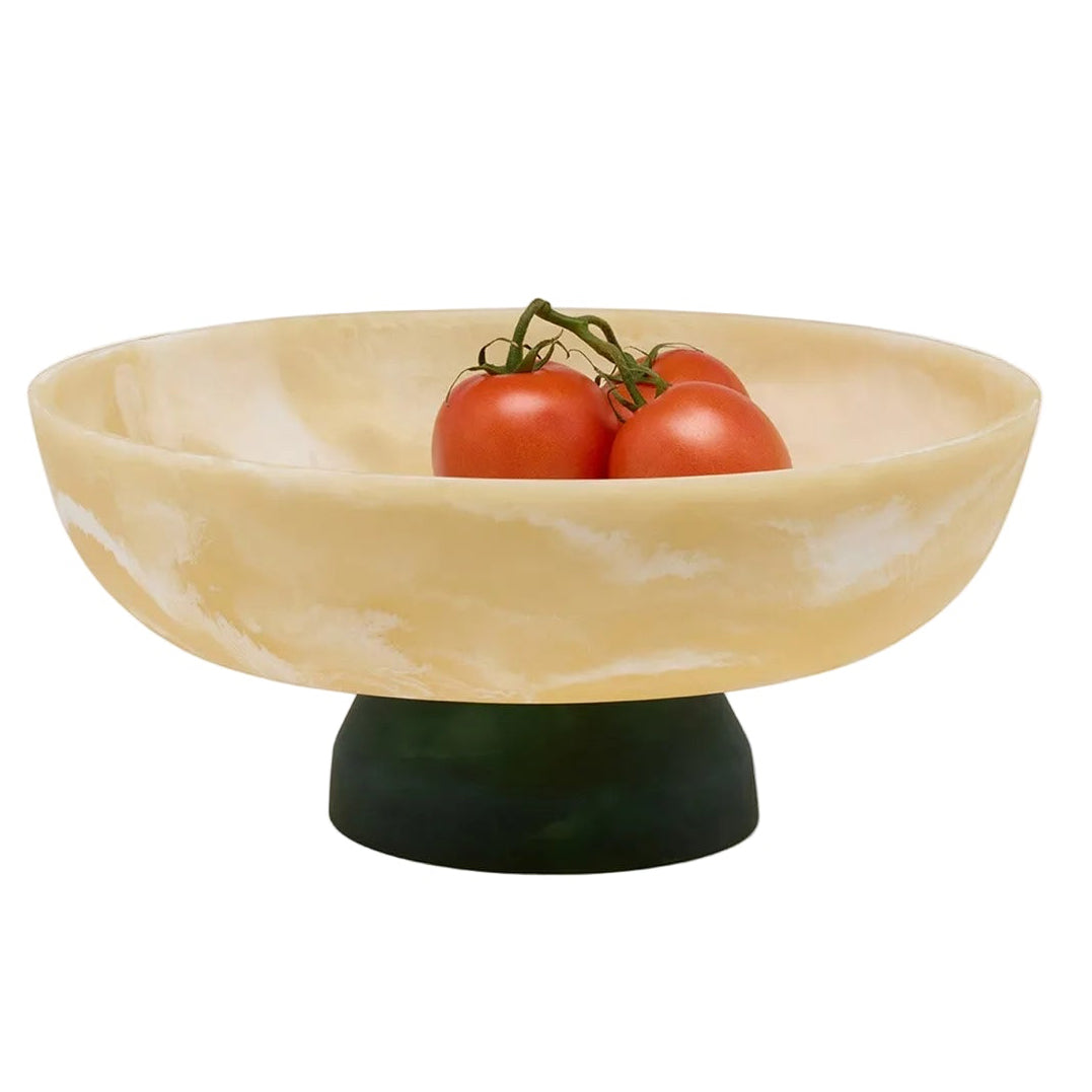 Decorative bowl with a green base holding three tomatoes on a white background