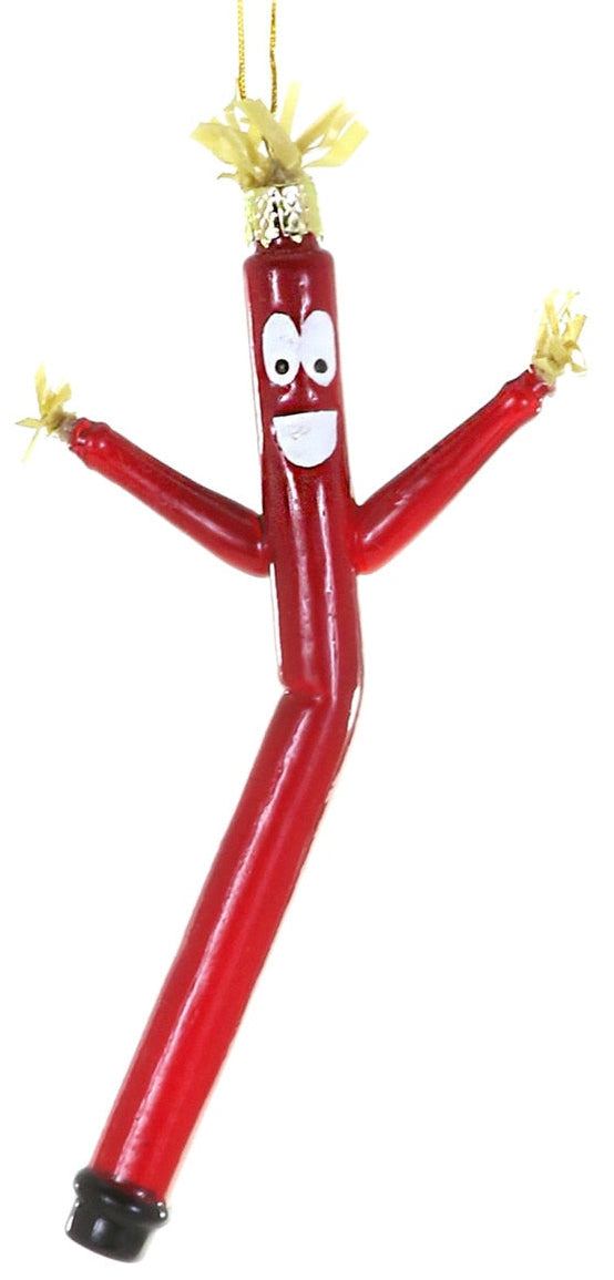 A red inflatable tube ornament shaped like a dancing person, with a cartoon face, yellow straw hair, and a hanging loop at the top, shown against a plain white background.