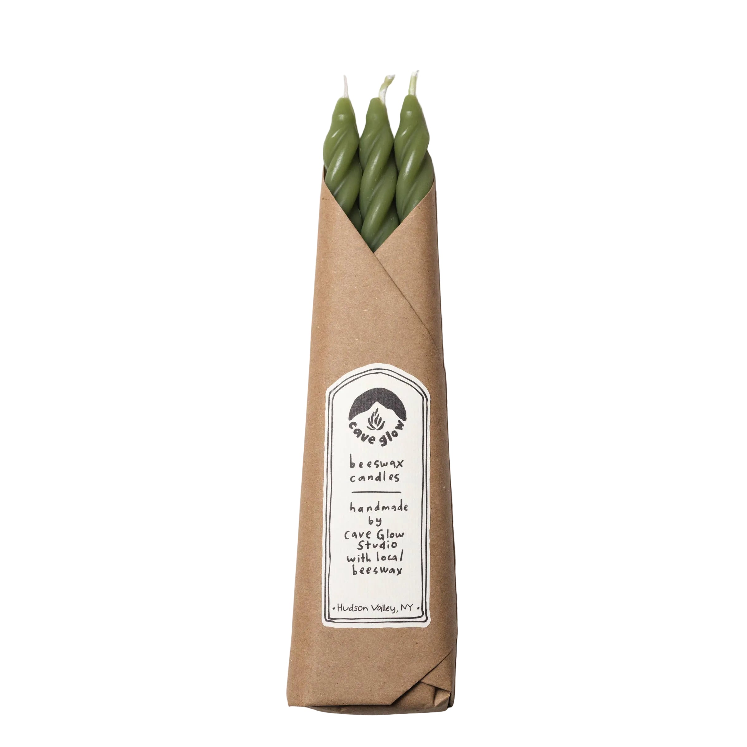Three green candles in a brown paper sleeve with a label on a white background