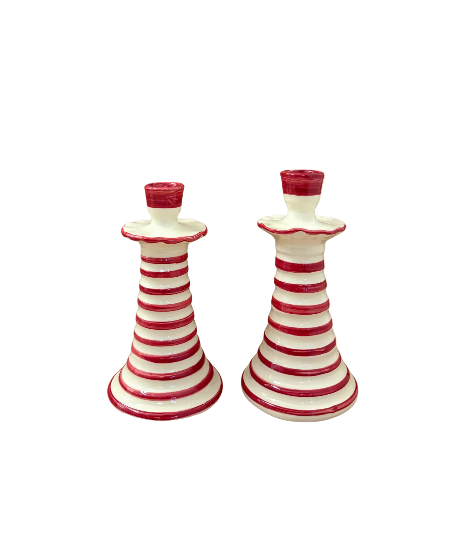 Two red and white striped ceramic candle holders on a beige background