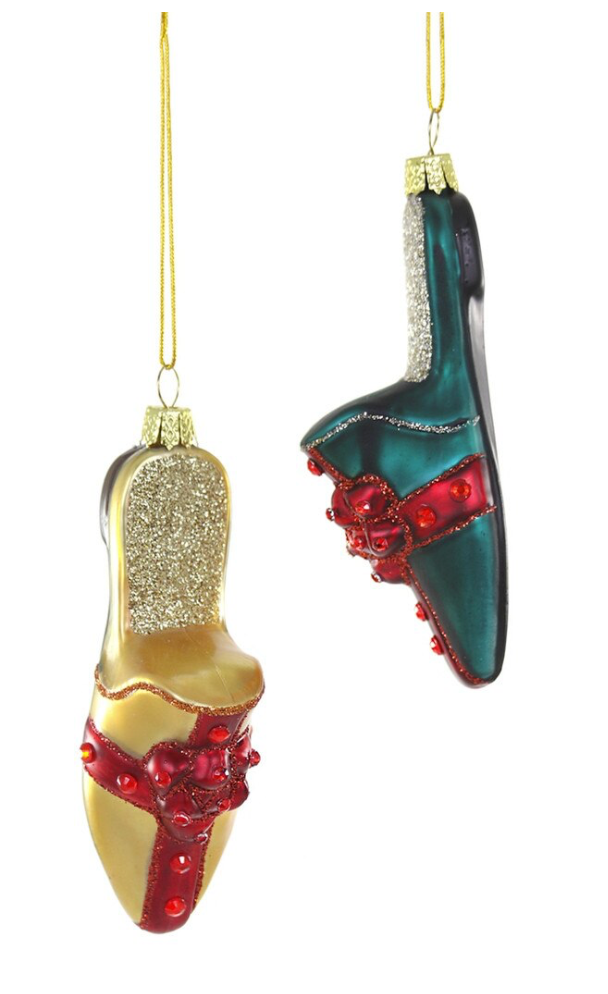 Two Christmas ornament shaped like high-heeled shoes, one in gold with red accents and one in dark green with red accents, hanging against a white background.