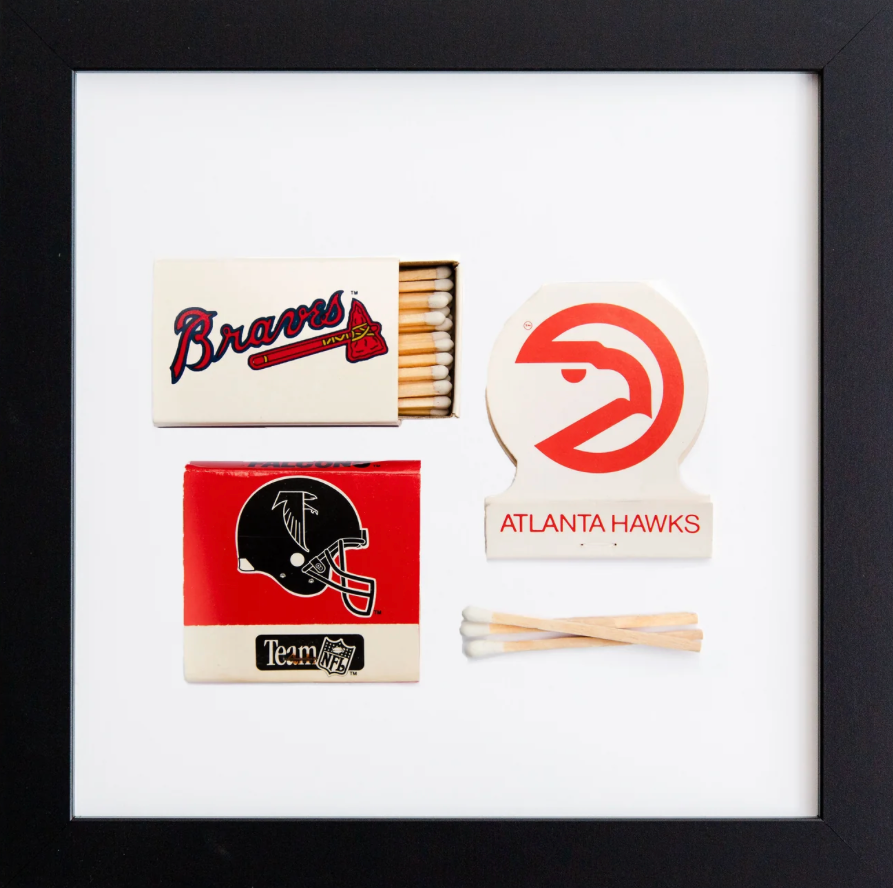 Framed display of sports-themed matchbooks and matchsticks with logos on a white background