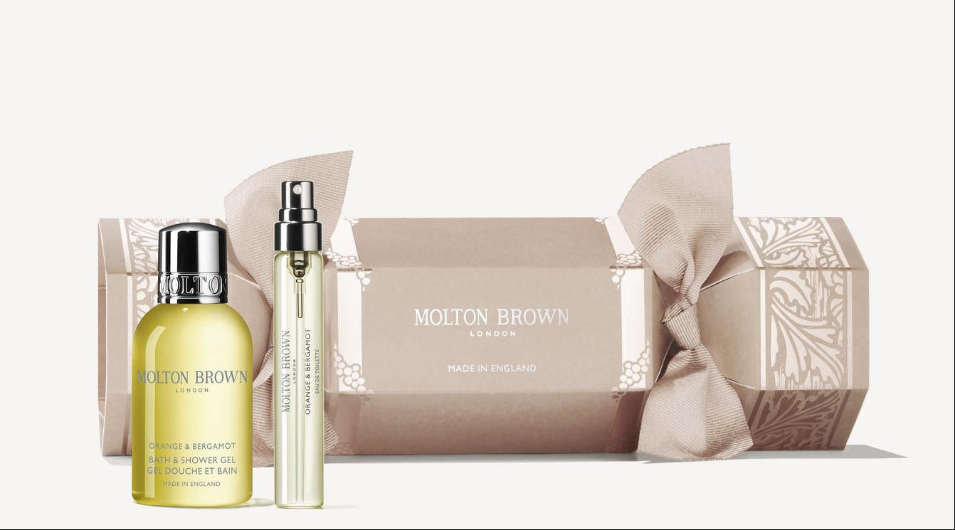 Molton Brown beauty products including a bottle, roller ball, and soap on a white background