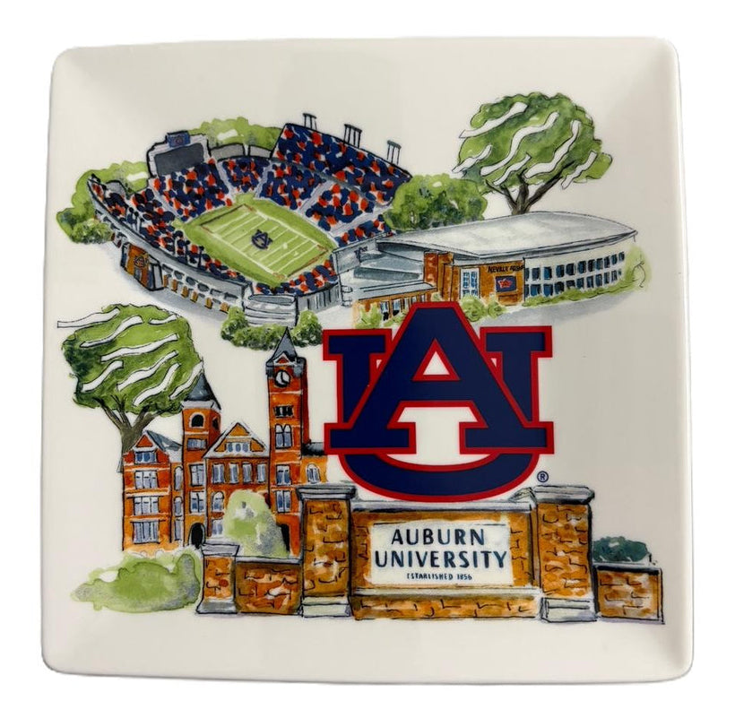 A square white ceramic plate featuring a colorful illustrated design of Auburn University, including the 'AU' logo, campus buildings, trees, and a stadium.