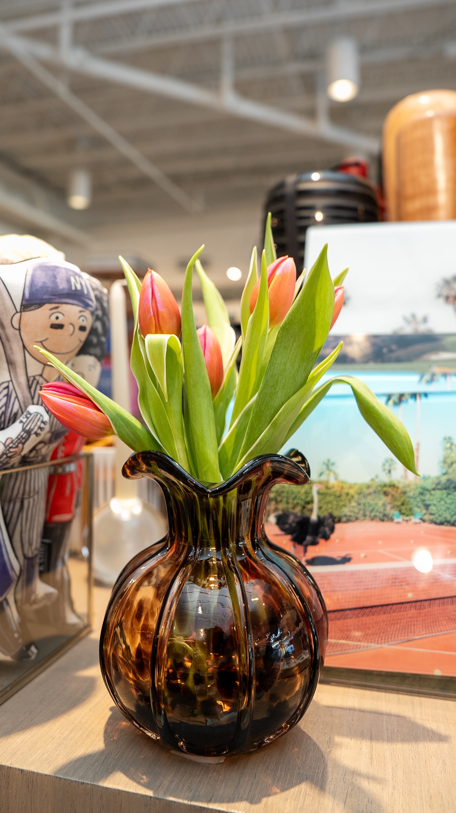 Vase with red tulips on a table in a store setting