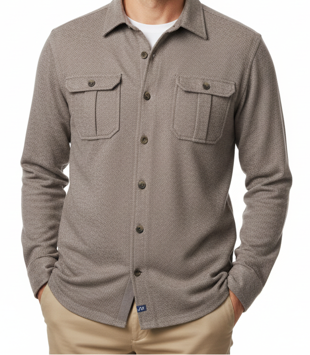 A smiling man wearing a taupe-gray long-sleeve button-up shirt with two chest pockets, paired with khaki pants, photographed against a solid white background.