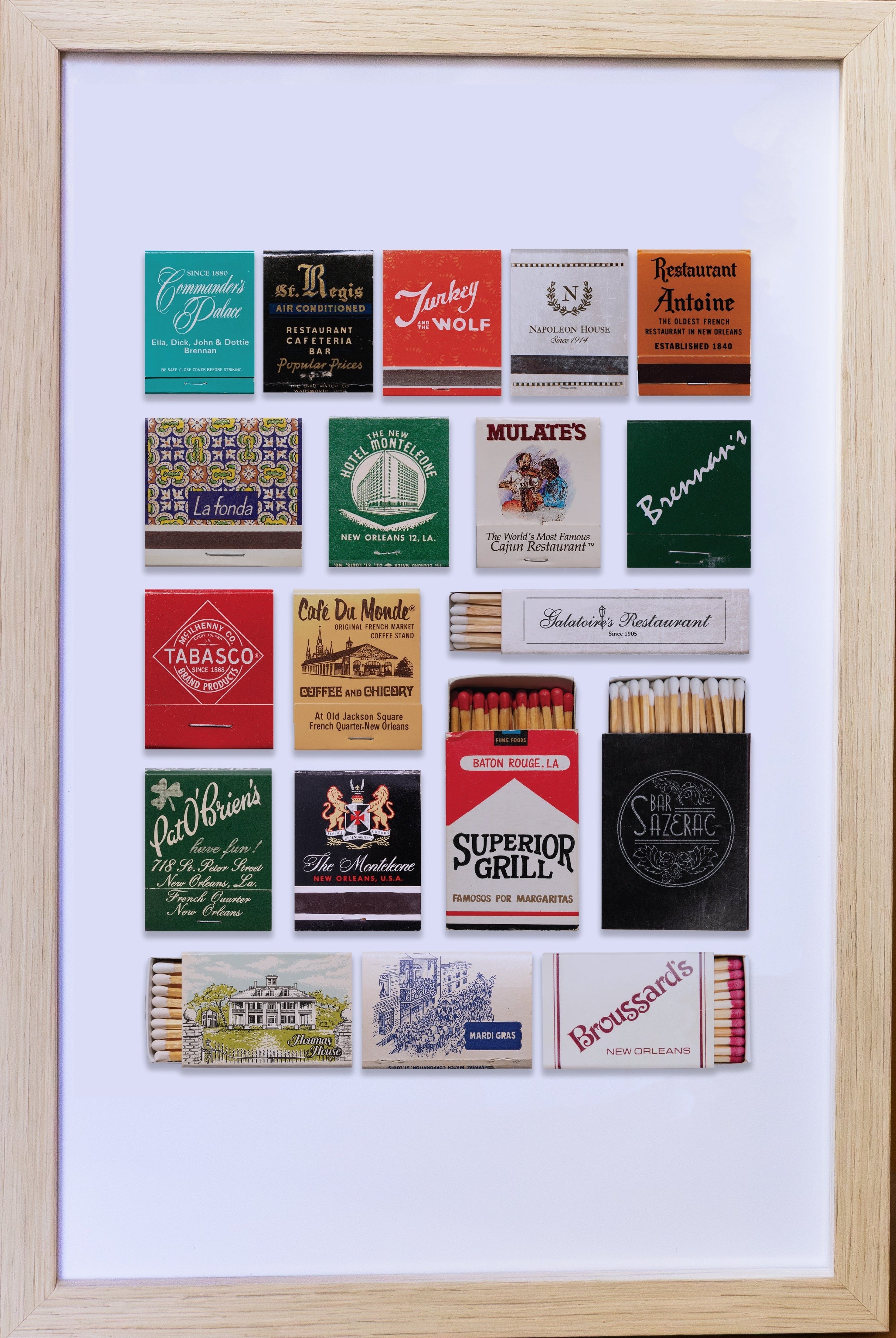 Framed collection of vintage matchbook covers on a wooden surface.