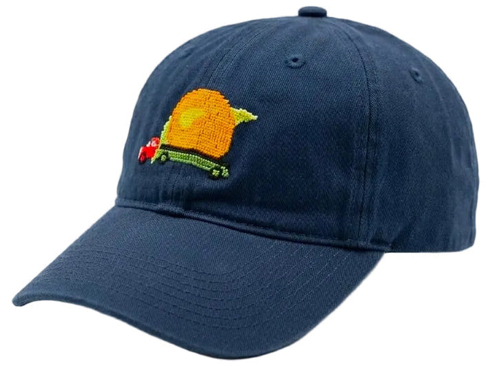 A navy blue cotton baseball cap featuring an embroidered design on the front. The embroidery depicts a yellow-orange sun with a red maple leaf and green text reading 'New Brunswick'.