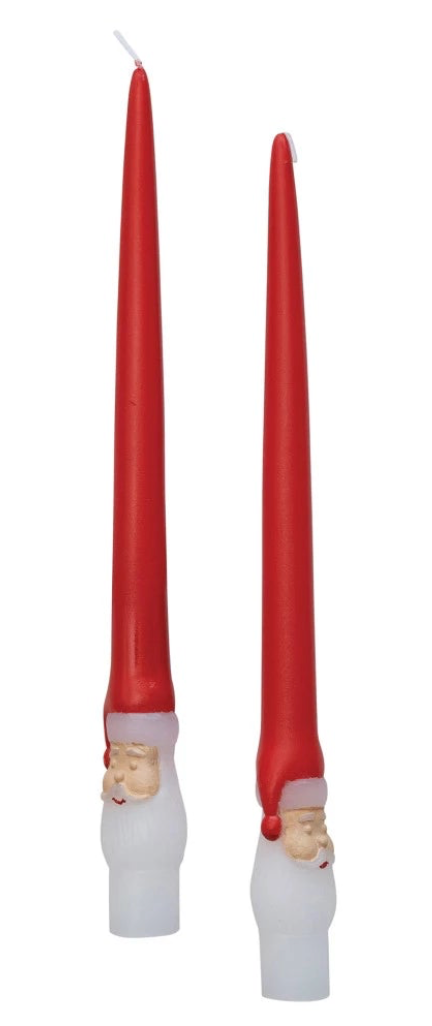 Two red candles with white candle holders shaped like gnomes on a white background