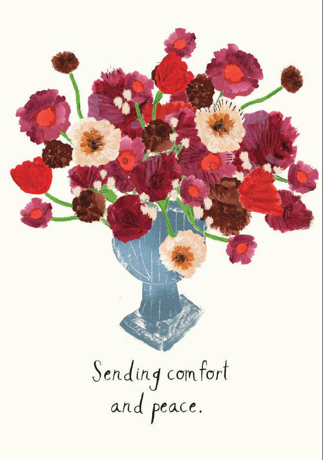 Floral arrangement in a blue vase with text 'Sending comfort and peace' on a white background