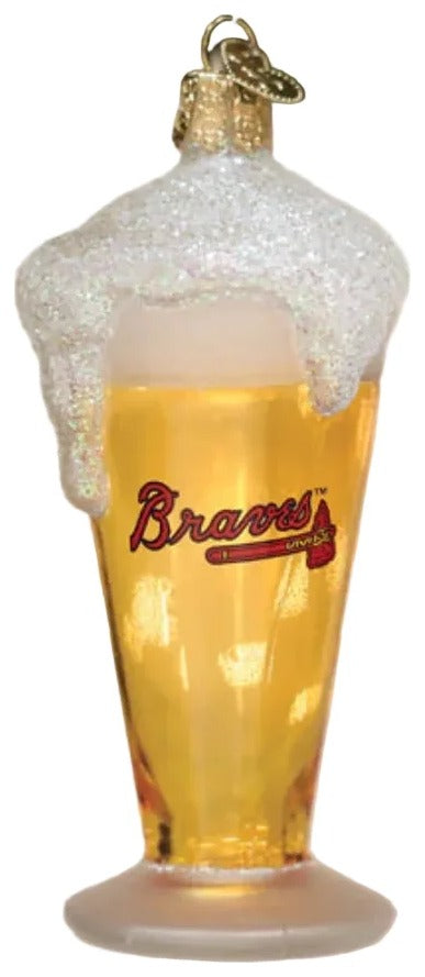 A glass of beer ornament with Atlanta Braves branding, hanging on a Christmas tree with holly and lights in the background.