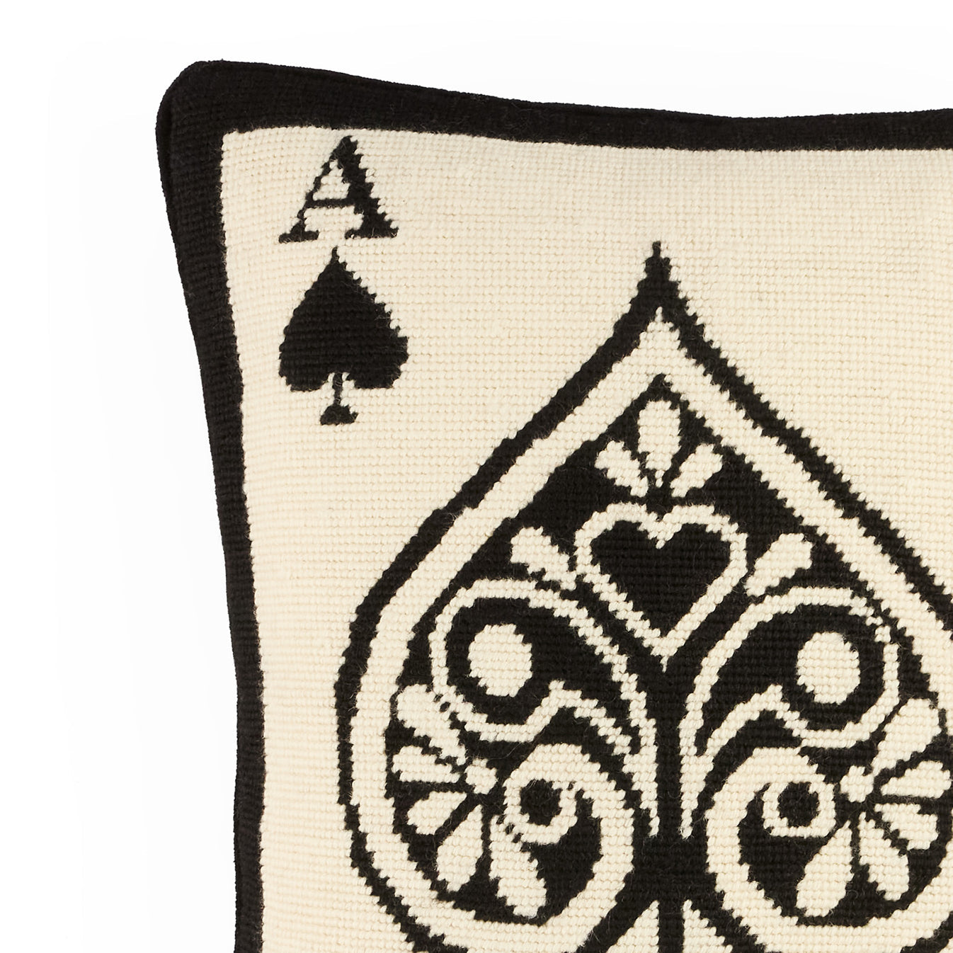 Pillow with a black and white ace of spades design on a beige background