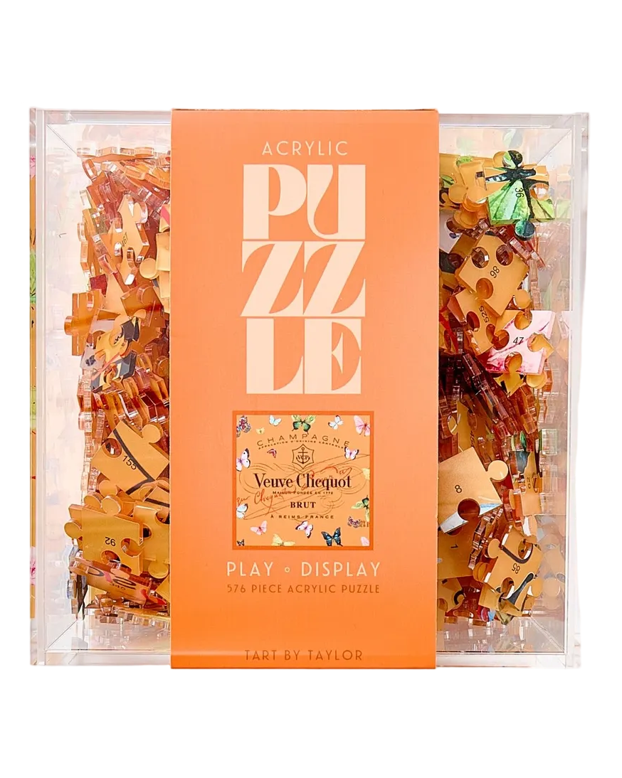 Puzzle packaging with orange cover and clear sides showing puzzle pieces.