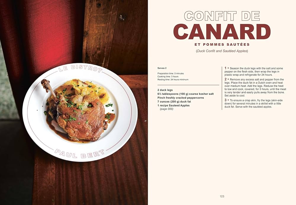 Plate of confit de canard with sautéed apples on a wooden table, accompanied by a recipe description.