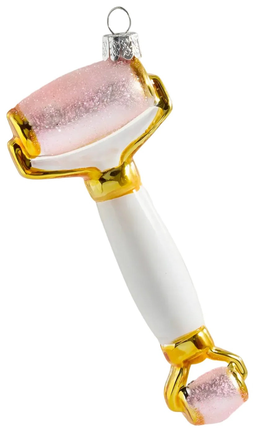 Beauty roller with pink stones on a white background