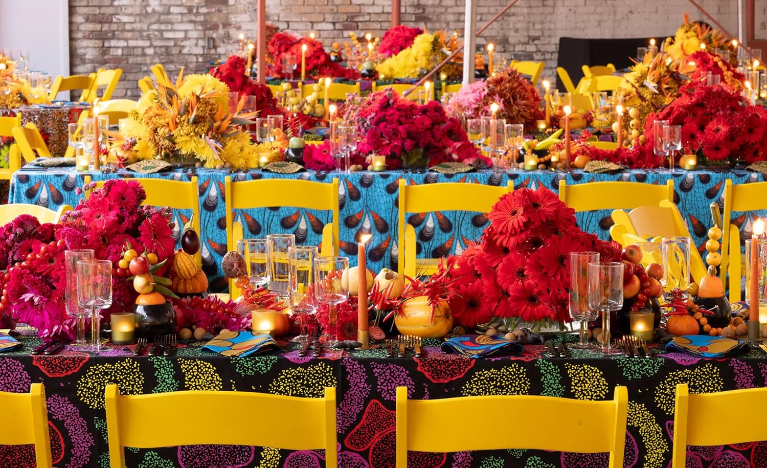 Decorative table setting with colorful flowers and yellow chairs in a formal setting.