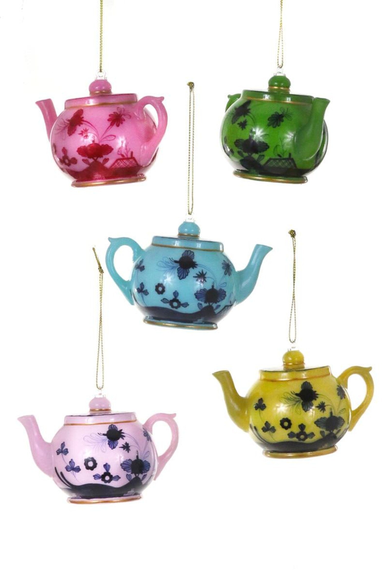Set of colorful teapots hanging against a white background
