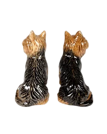 Two ceramic dog figurines sitting side by side on a gray background