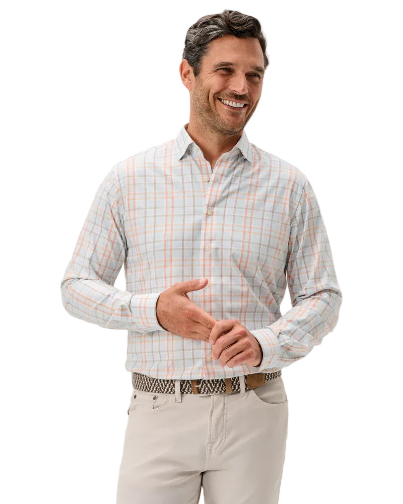 Man wearing a checkered shirt and beige pants against a light gray background