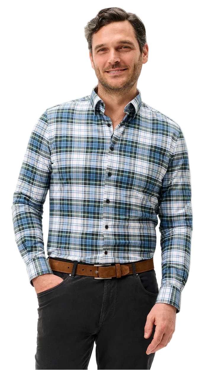 A man wearing a long-sleeve button-down plaid shirt in blue, green, and white, paired with a brown belt and dark gray trousers, standing against a light gray studio background.