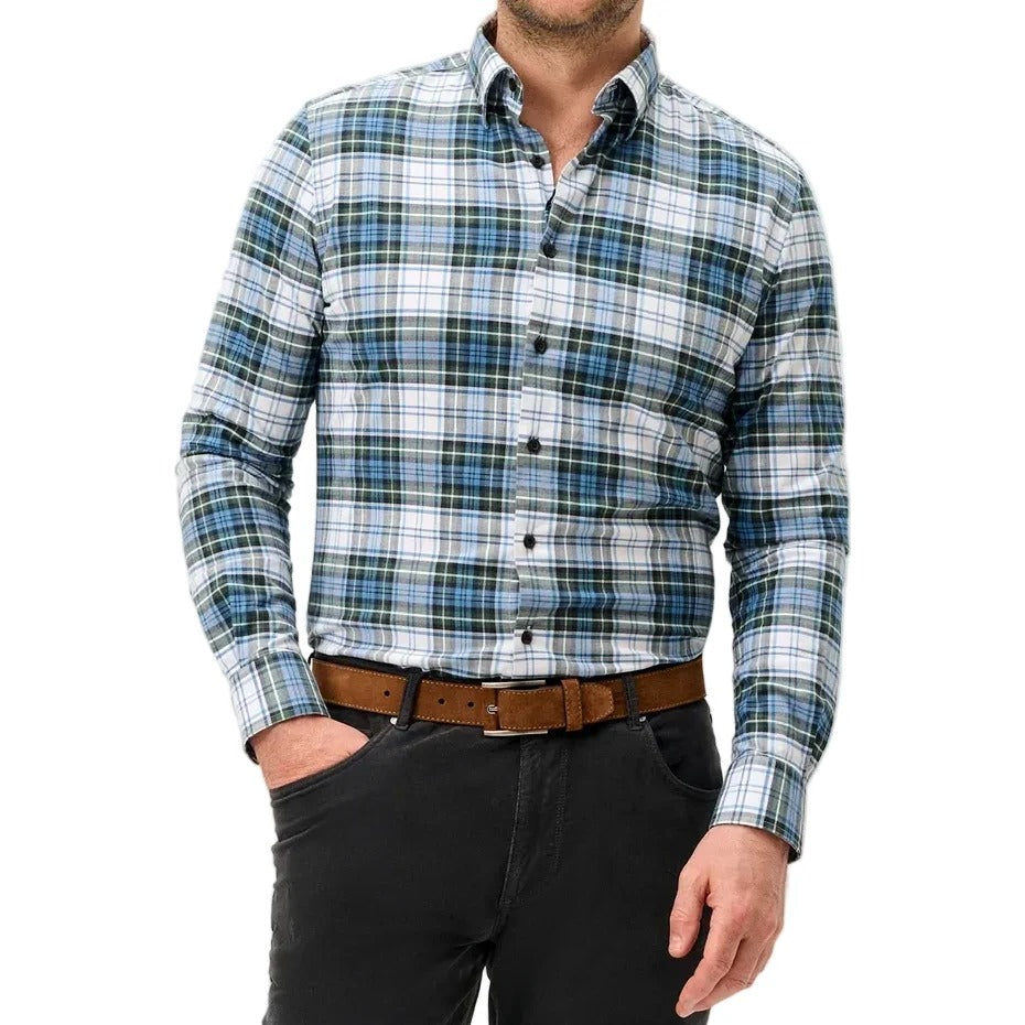 A man wearing a long-sleeve button-down plaid shirt in blue, green, and white, paired with a brown belt and dark gray trousers, standing against a light gray studio background.