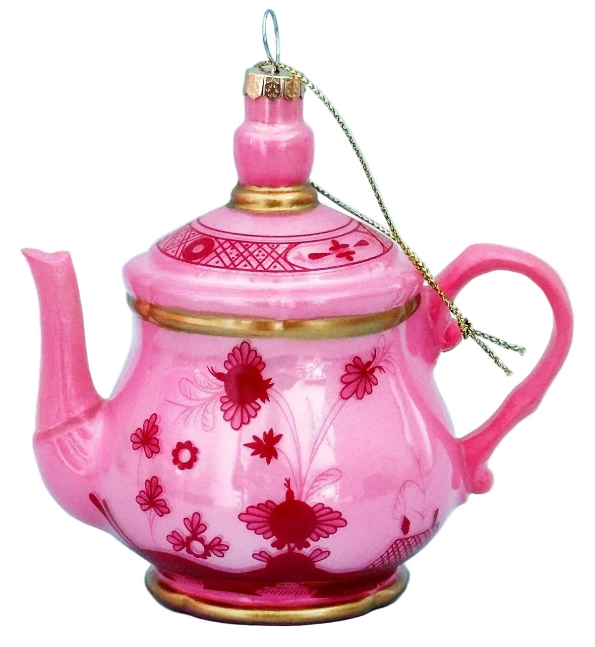 A pink ceramic ornament shaped like a teapot, decorated with red floral patterns and gold trim, hanging against a light blue background.
