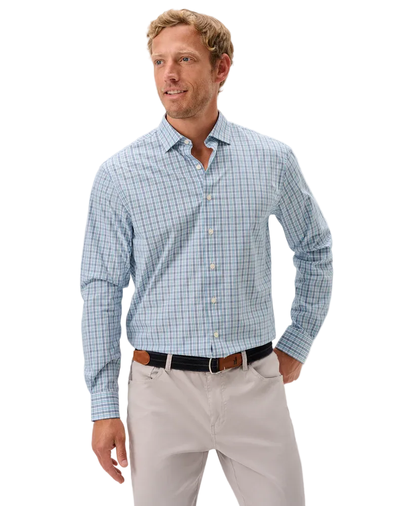 Man wearing a blue checkered shirt and light gray pants on a white background