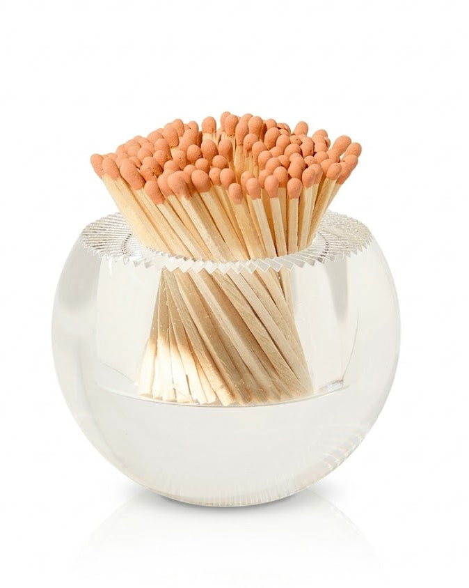 Clear glass match holder with matches on a white background