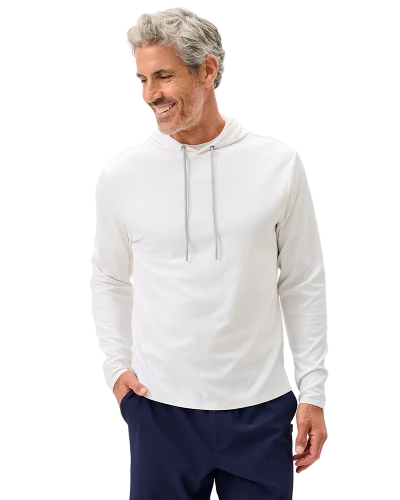 Man wearing a white hoodie and navy pants on a light gray background