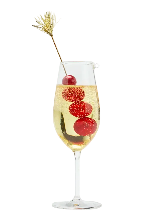 Glass of champagne with red berries and a decorative straw on a white background