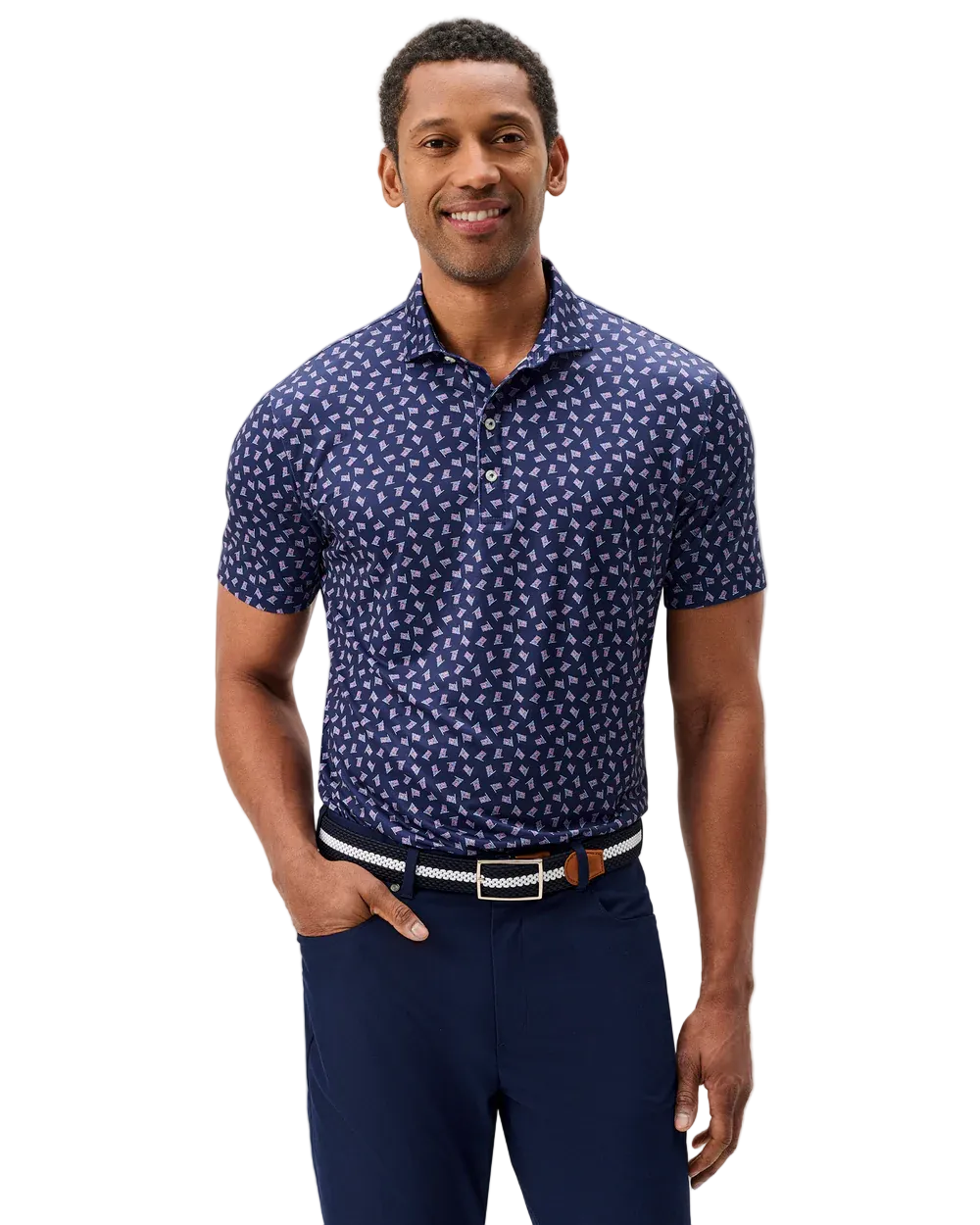 Man wearing a blue patterned shirt and navy pants on a light gray background