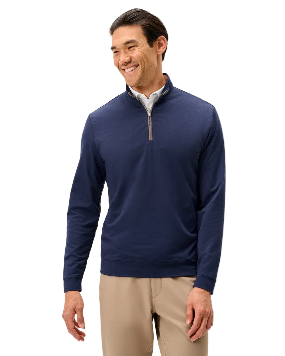 Man wearing a navy blue quarter-zip pullover with beige pants on a light gray background